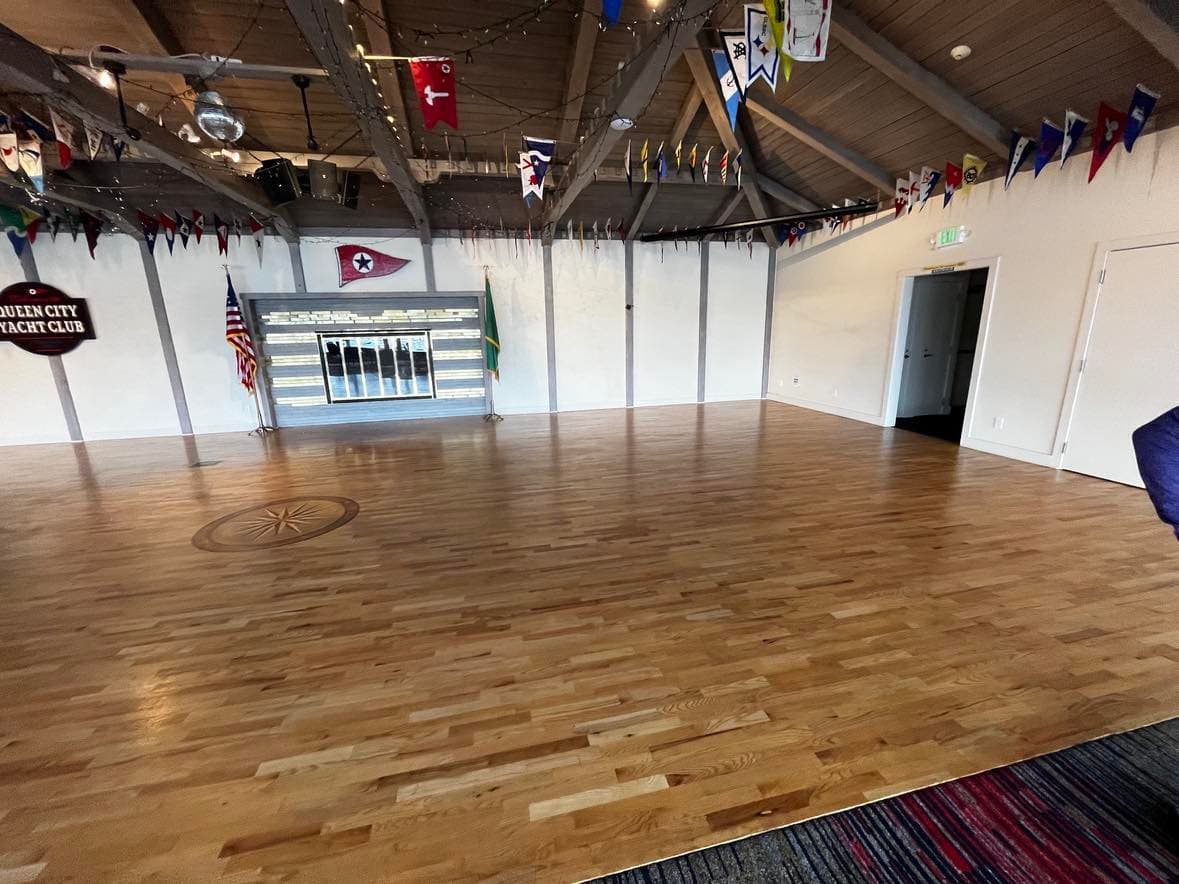 The right side of the newly installed hardwood flooring at this yacht club, with a custom compass symbol in the middle